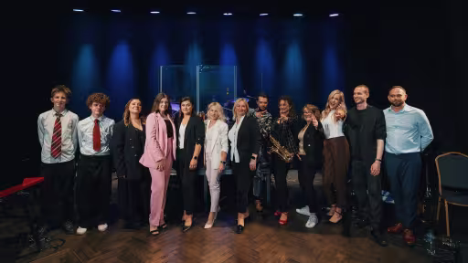 Grupa ludzi stoi na scenie